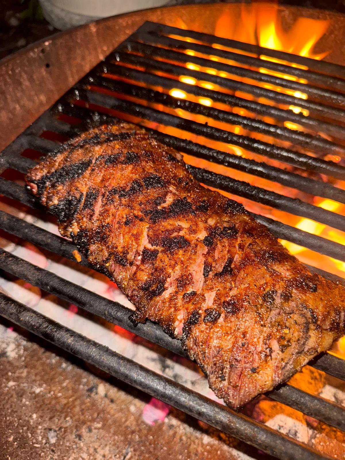 Steak searing over a live fire grill.