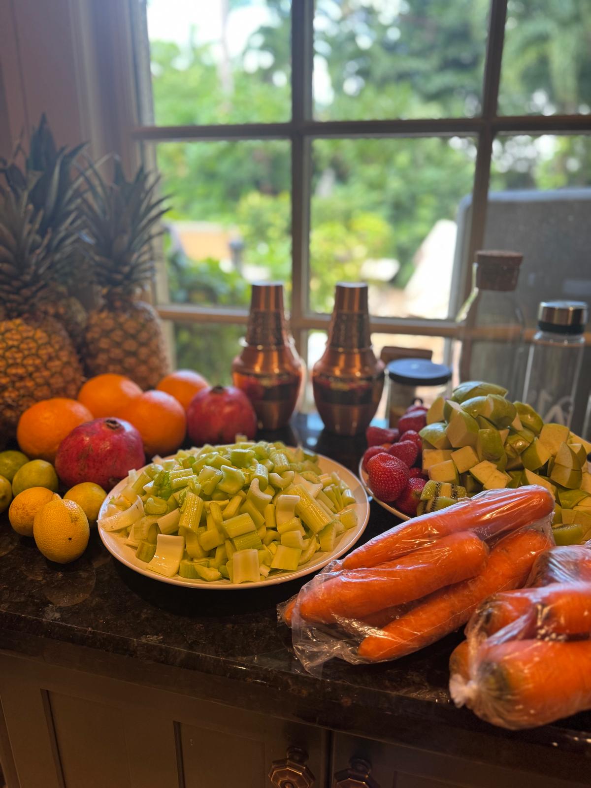 Fresh fruit and vegetables prepped on a kitchen counter.