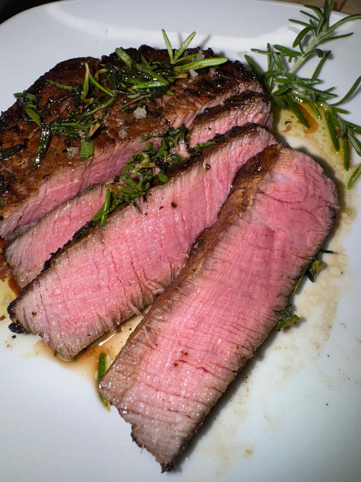 Sliced steak finished with herbs.