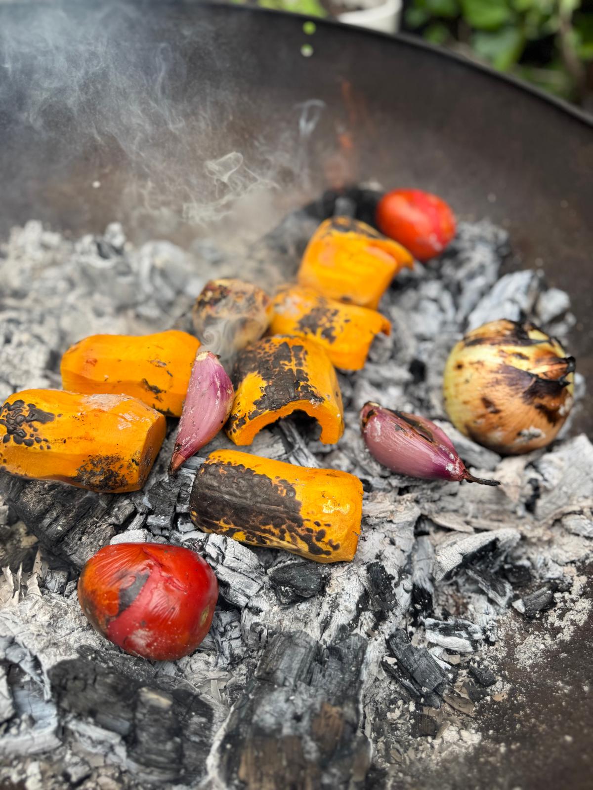 Vegetables roasting directly over embers.