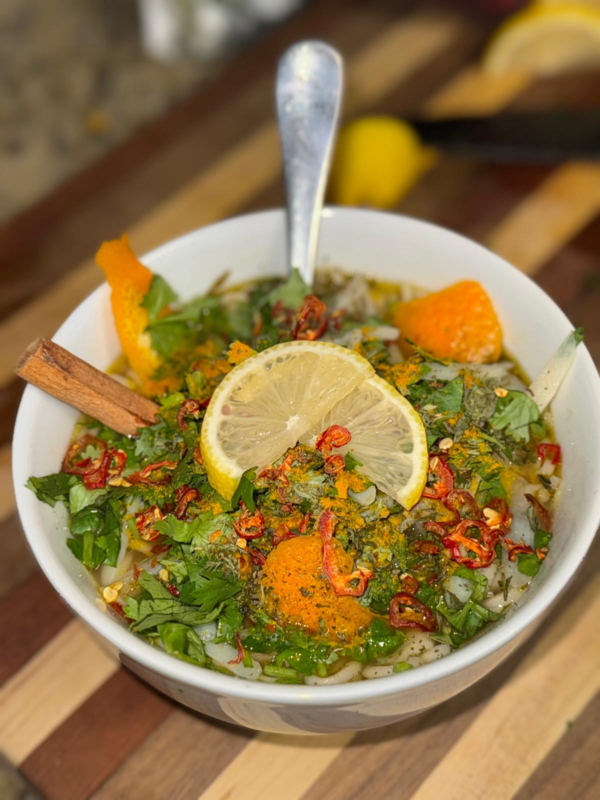 A bright soup topped with herbs and lemon.